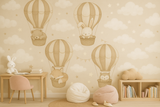 Children's room with wall mural of hot air balloons and animals, pink chair, and bookshelf.