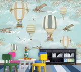 Blue cartoon plane and hot air balloon mural wallpaper in a children's nursery